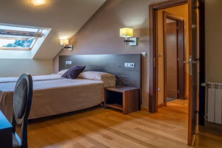 Habitación luminosa del Hotel Báltico 3 estrellas en Luarca con cama de matrimonio.